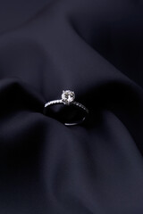 Diamond ring on black silk background with copy space