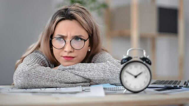 Upset young business student freelancer woman lying on desk having deadline problem feeling fatigue