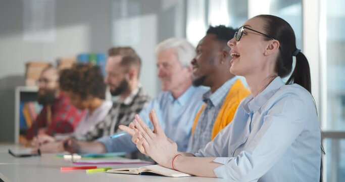 Row of multiethnic business people writing lecture at conference