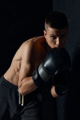 Fototapeta na wymiar boxers two black gloves bent down sport bodybuilder pumped up torso