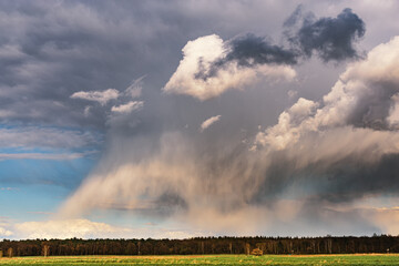 a cumulonimbus storm cloud over the fields and convective rainfall.