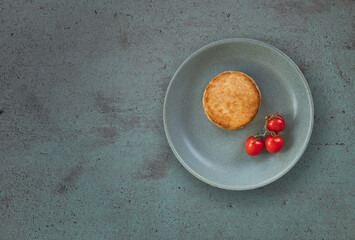 Meat chicken cutlet with cherry tomatoes on plate on textured background, copy space.