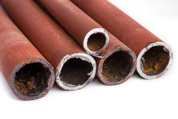 Used rusty metal thick pipes on a white