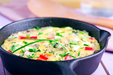 Egg omelette with vegetables on a wooden  table
