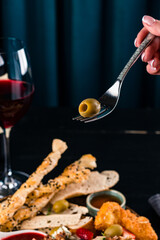 one green olive on a fork