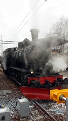 A steam locomotive is in the station and ready to go