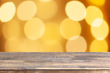wood table top on blur yellow christmas tree lights background