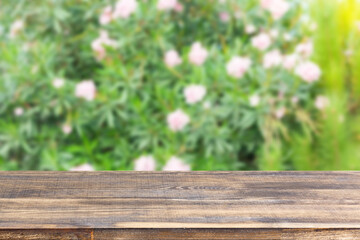 Fototapeta premium wood table top on blur bush with flowers background