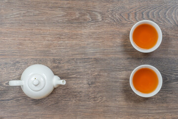 two white small tea bowls and teapot on wooden table, above minimalistic shot