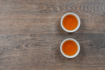 Fototapeta na wymiar two white small tea bowls on wooden table, above minimalistic shot