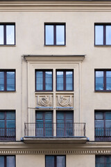 Soviet architecture classical facade building front view. Architectural detail balcony decorated with ancient theatre masks.