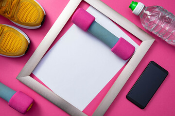 sports at home - yellow sneakers, a metal frame, a cell phone and a bottle of water, dumbbells