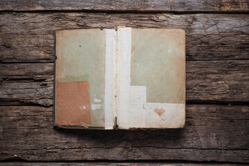 Open old book on the wooden desk table flat lay background.