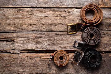 Fototapeta premium Old retro style male belts on the wooden table flat lay background with copy space.