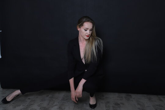 Photo of a fashion girl on a black background in black clothes light skin