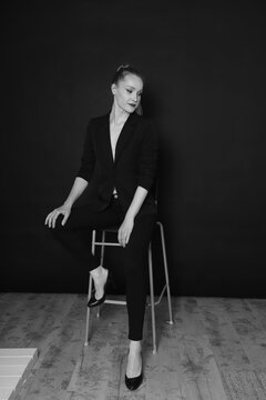 Black and white photo of a fashion girl on a black background in black clothes light skin