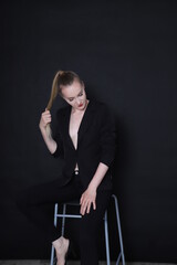 Fototapeta na wymiar Photo of a fashion girl on a black background in black clothes light skin