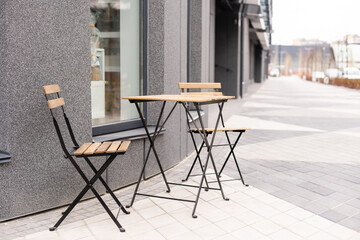 The photo shows a table and chairs on an open terrace near the cafe