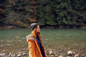 woman walks along the river in the forest nature fresh air