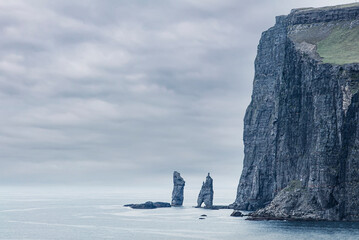 Two famous sea stacks Risin og Kellingin (the Giant and his Wife) in the Faroe Islands.  View from village Tjornuvik on Streymoy island, Faroe Islands