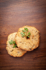 Plain dry dahi badhe for preparation of chaat, Garnished with cumin and green fresh coriander over wooden background.
