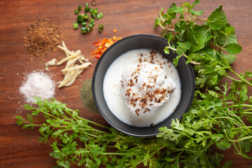 Chaat Dahi vada (AKA Dahi Bhalla, Doi Bora, mosaru vade, Dahi Bara, thayir vadai, perugu vada). Prepared by soaking vadas in thick curd (yogurt). Garnished with cumin and green fresh coriander