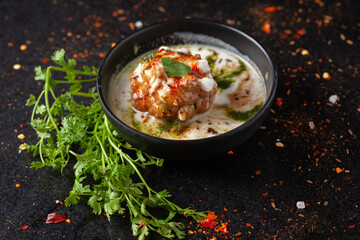 Chaat Dahi vada (AKA Dahi Bhalla, Doi Bora, mosaru vade, Dahi Bara, thayir vadai, perugu vada). Prepared by soaking vadas in thick curd (yogurt). Garnished with cumin and green fresh coriander