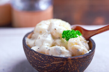 gnocchi in coconut sauce, served in a coconut bowl