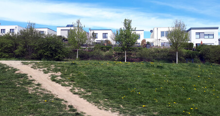 Neubaugebiet mit Flachdachhäusern im Grünen am Rande von Trier.