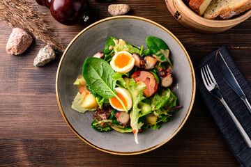 Salad with octopus. In a plate of lettuce leaves, slices of tomato, eggs