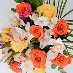 Ceramic vase with roses, cymbidium, alstroemeria and greenery.