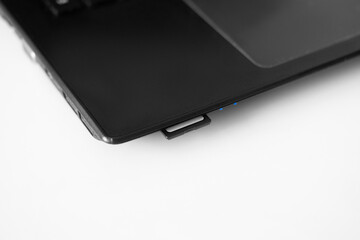 Close-up of an SD card inserted into the card reader of a laptop.