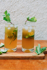 Mojito cocktail with lemon and mint in glass on a wooden board. Summer drink.