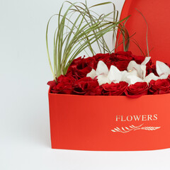 Heart type box with red roses, orchids, cymbidium and beergras.