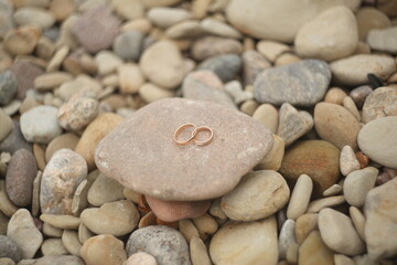Golden wedding rings on a stones. Rustic wedding concept.