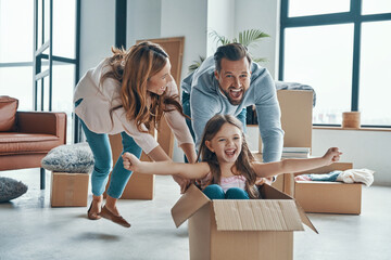 Family smiling and unboxing their stuff while moving into a new apartment - 433782749