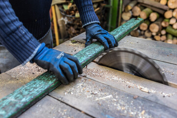 Eine alte Latte aus Holz mit der Kreissäge zersägen