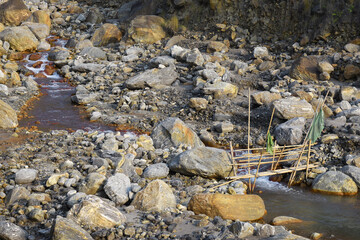 Villagers makeshift Bamboo bridge over high current river.