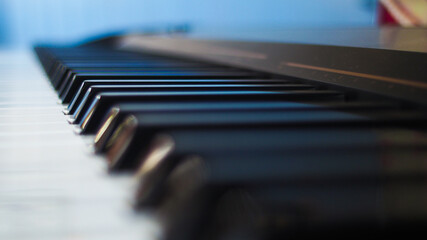 Vue rapprochée sur les touches d'un piano, dans une pièce bleuâtre
