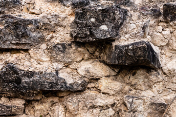 Close up view of surface of rocks at Vecdole castle in Latvia built 1226 . Black grey stonewall texture. Old granite brick construction. Abstract background of vintage rock structure