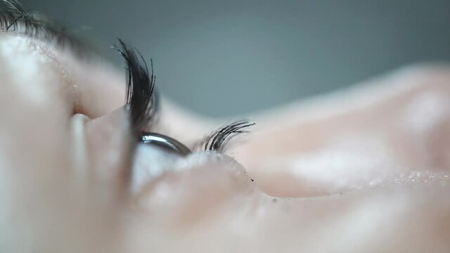 Closeup, macro shot of an woman's eye blinking and looking away, mascara is applied to eyelashes