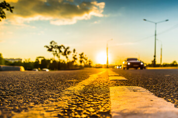 Sunset in the country, the stream of cars passing by on the highway. Wide angle view of the level of the dividing line
