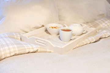 Fototapeta na wymiar morning breakfast at bed - striped teaset on breakfast tray in bedroom