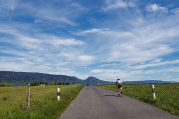 Cycliste sur une route de campagne dans le Jura Vaudois, Suisse
