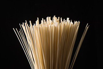 close up of dry noodles made from wheat flour on black background