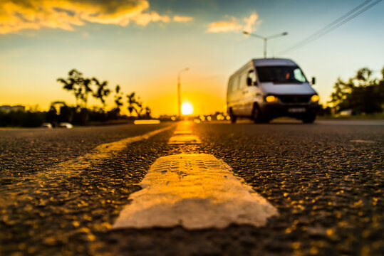 Sunset in the country, the van on the highway. Wide angle view of the level of the dividing line
