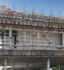 Restoration and restoration of an old building. Metal scaffolding around a large and tall building at a construction site.