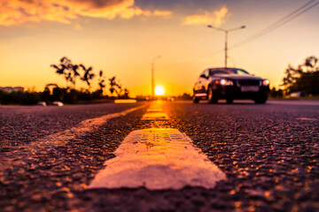 Sunset in the country, the car on the highway. Wide angle view of the level of the dividing line