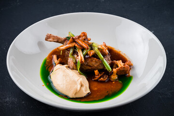 Roasted lamb chops with chanterelles and vegetables on decorated table