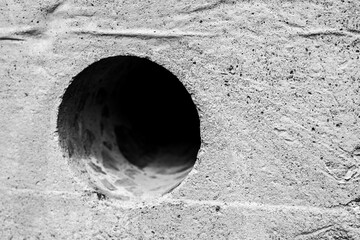 Hole in the concrete wall. Close up side view
